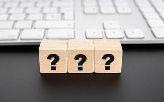 Questions Mark on wooden block and computer keyboard. FAQ Answer photo