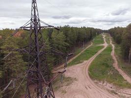 Aerial view of high-voltage power lines passing through the forest area. photo