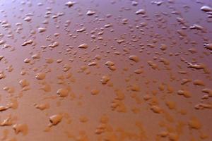 gotas de agua después de la lluvia sobre un fondo naranja foto