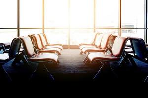 Departure lounge with empty chairs in the terminal of airport, waiting area photo