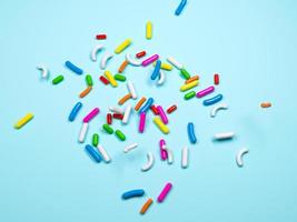 Colorful sprinkles on a blue background, top view isolated 3d Illustration 3d rendering photo