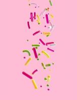 Sprinkles falling from top in 3d illustration isolated on pink background photo