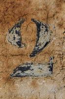 number 2, black number painted on white and brown wood background, number two painted on one white weathered paint wood textured background photo