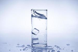 Ice cube fell into the glass of water.Water splashed from the clear glass.Fresh concept photo