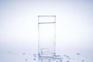 Ice cube fell into the glass of water.Water splashed from the clear glass.Fresh concept photo