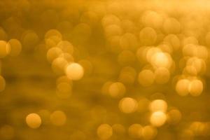 Bokeh light from reflection of golden water surface in the evening sunset photo