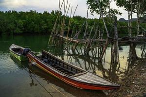 The broken ship, an Old abandoned ship on the ocean shore.Thai wooden motorboat. photo