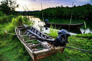 The broken ship, an Old abandoned ship on the ocean shore.Thai wooden motorboat. photo