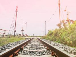 un antiguo ferrocarril, la ruta de viaje cuando el sol se pone y se ve la naturaleza y el cielo. foto