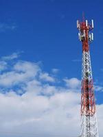 torre telefónica con nubes blancas en el fondo. foto