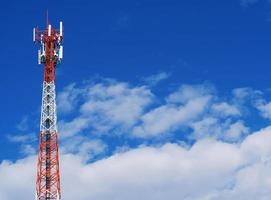 torre telefónica con nubes blancas en el fondo. foto