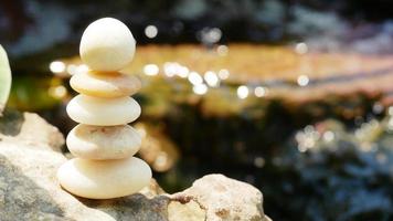 The Balance Stones are stacked as pyramids in a soft natural bokeh background, representing the calm philosophical concept of Jainism's wellness. photo