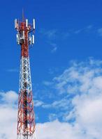 torre telefónica con nubes blancas en el fondo. foto