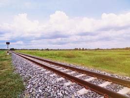 un antiguo ferrocarril, la ruta de viaje cuando el sol se pone y se ve la naturaleza y el cielo. foto