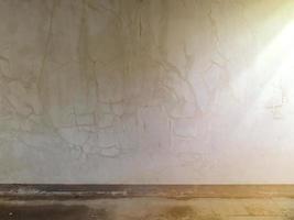 el antiguo fondo de la pared tiene grietas y la luz brilla a través de él. foto