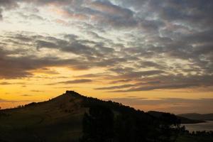 Orange sunset in the mountains near the lake in summer photo