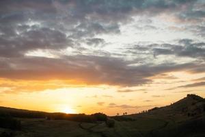 colorido atardecer en el fondo de las montañas con hermosas nubes foto