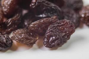 Black dried raisins on a white background photo