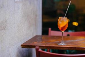 cóctel de licores de aperol fresco, sobre una mesa de madera en el restaurante. toma horizontal de bebida de verano. líquido naranja con hielo. bebida de aperitivo. foto