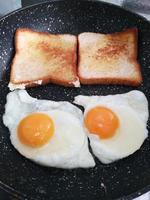 bread and eggs in breakfast time photo