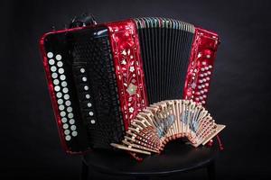 Russian folk instruments.Red bayan on a black background.Russian accordion photo