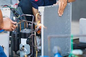 Close up of Air Conditioning Repair team use fuel gases and oxygen to weld or cut metals, Oxy-fuel welding and oxy-fuel cutting processes, repairman on the floor fixing air conditioning system photo