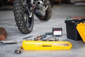 conceptos de reparación y mantenimiento, herramientas de trabajo en el suelo para reparar motocicletas en el garaje del taller foto