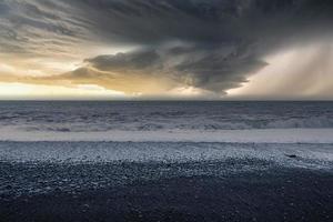 vista panorámica de la playa negra de reynisfjara contra el cielo nublado durante la puesta de sol foto