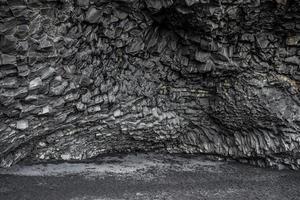 Beautiful basalt rock columns formation on black seashore of Reynisfjara Beach photo