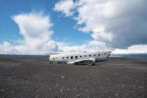 accidente de avión militar roto en la playa de arena negra en solheimasandur contra el cielo foto