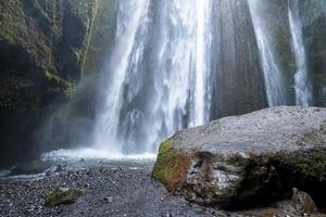 Scenic cascades of Gljufrafoss by rock flowing from mountain hidden in cliffs photo