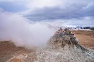 View of steaming fumarole in geothermal area of Hverir at Namafjall against sky photo