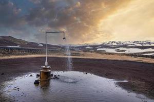 Hot spring shower from geothermal power at Krafla against mountain