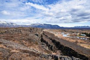 Scenic view of dramatic landscape and mountains against cloudy blue sky photo
