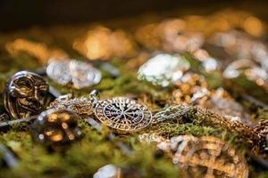 primer plano de varias joyas vikingas en una bandeja decorada con musgo en exhibición en la tienda foto