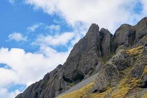 vista de ángulo bajo de formaciones rocosas en el paisaje volcánico contra el cielo azul foto