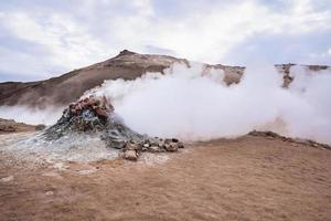 View of steam emitting from fumarole in geothermal area of Hverir against sky photo