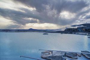 Beautiful view of blue lagoon in geothermal spa against cloudscape in valley photo
