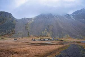 Distant view of ancient Viking village under Vestrahorn mountain against sky photo