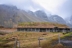 casa tradicional de madera en el pueblo vikingo bajo la montaña vestrahorn contra el cielo