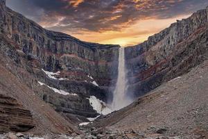 hermosas cascadas de hengifoss escénicas que caen de las montañas durante la puesta de sol foto