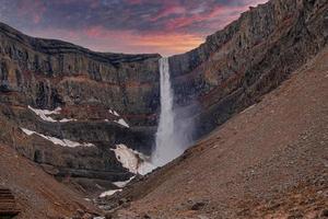 hermosas cascadas de hengifoss que caen de las montañas contra el cielo dramático foto