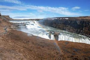 Tourists exploring beautiful Gullfoss waterfall in Golden Circle against sky photo