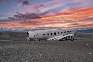 View of damaged aircraft wreck at black sand beach in Solheimasandur in sunset photo