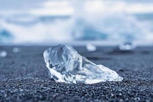 Close-up of beautiful ice chunk on black sand shore of Diamond beach photo