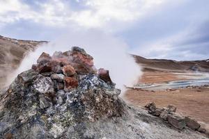 fumarola humeante en el área geotérmica de hverir en namafjall contra el cielo nublado foto