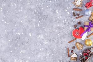 Christmas background. Christmas gift, toys, gingerbread cookies, spices and decorations on wooden background. Top view photo