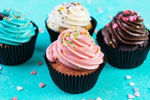 Tasty colorful cupcakes isolated on blue background. Delicious cupcake photo