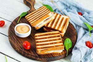 Club sandwich with ham, tomato, cheese and spinach. Grilled panini photo