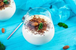 Sweet milk pudding with almonds and chocolate chips on blue background photo